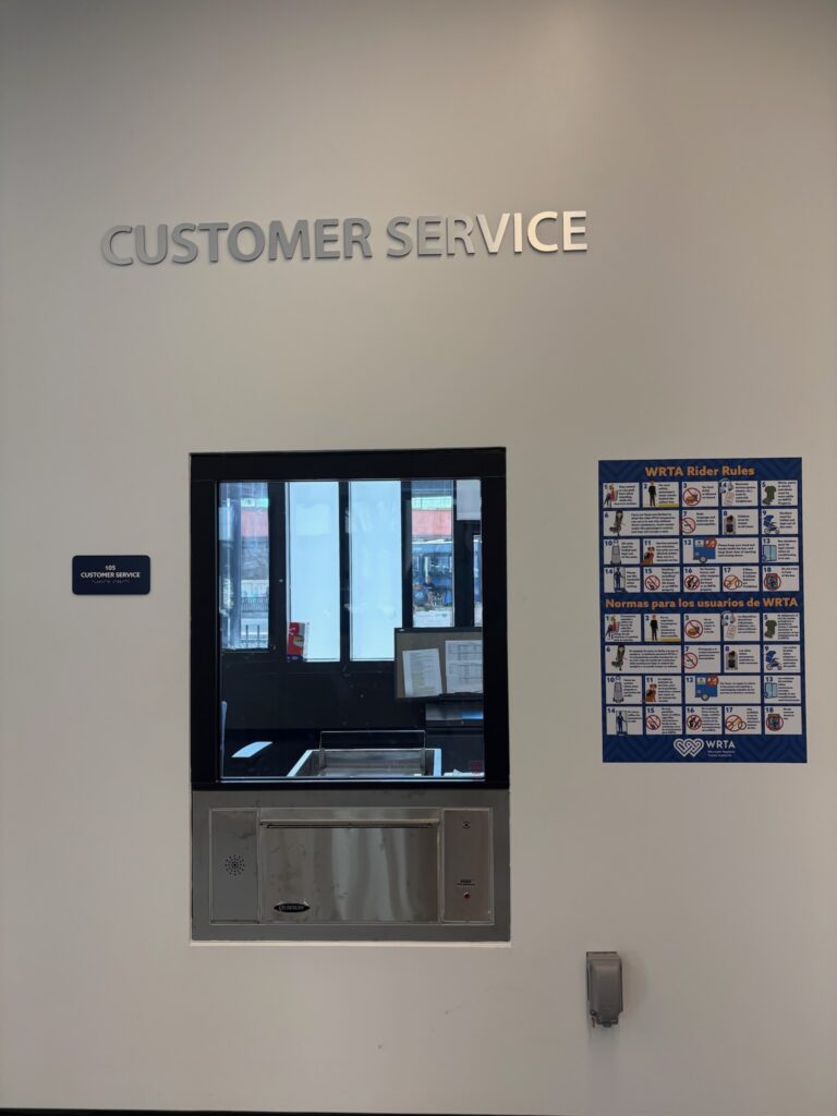 Image of a customer service window and poster of imagery depicting Rider Rules.